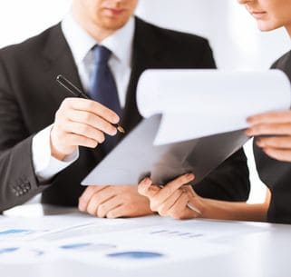 people in business signing paperwork